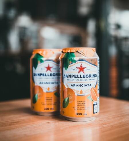 two cans of san pellegrino are sitting on a table